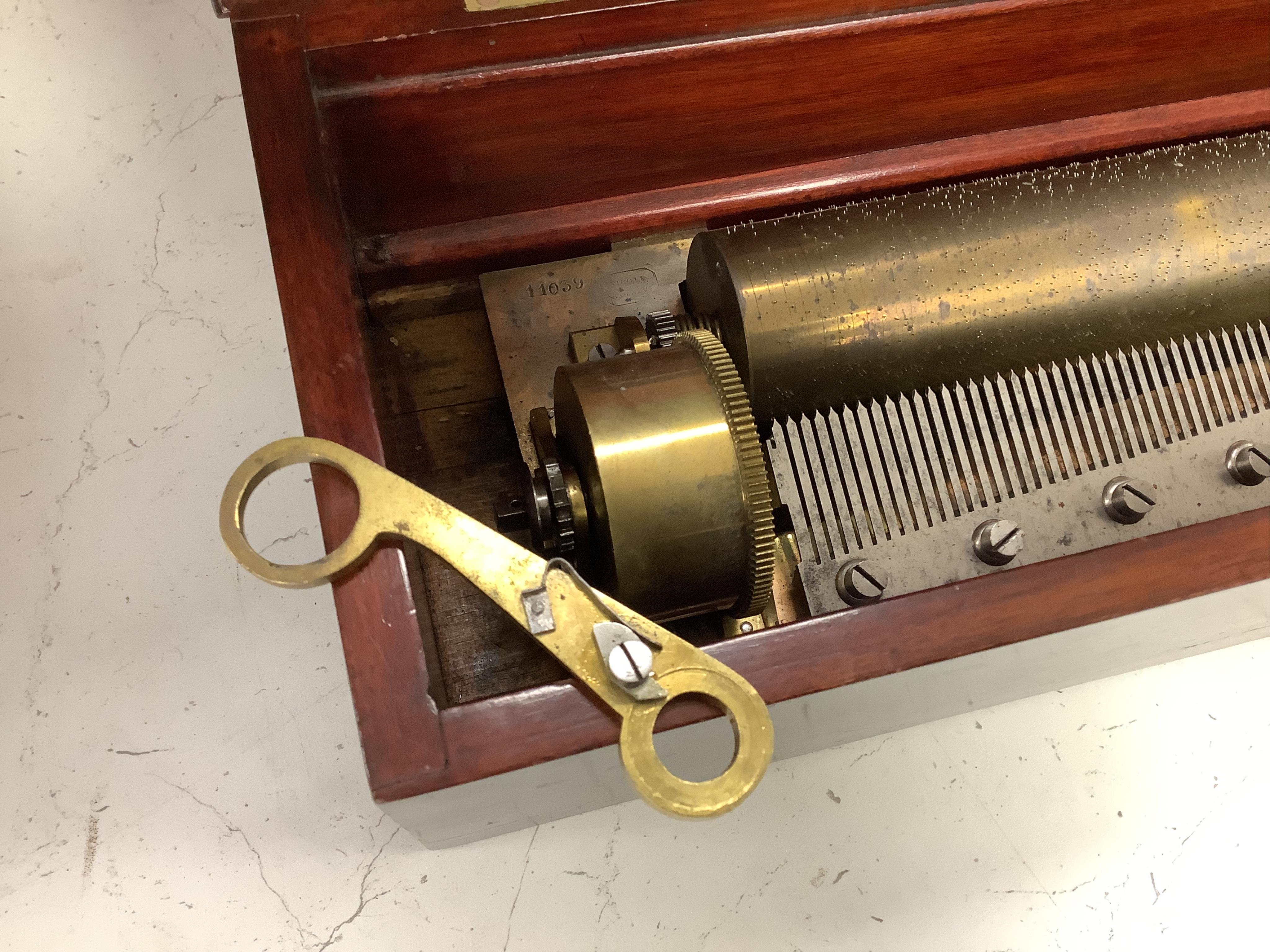 A 19th century Swiss rosewood and marquetry cased cylinder music box, signed Nicole a Geneve, with engraved serial number 11039, the cylinder is 32.5cm long, the case; 51cm wide, 15cm high, 17cm deep